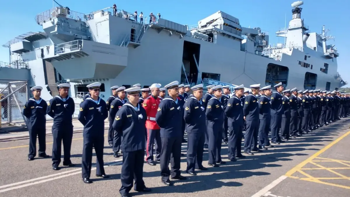 Militares da Marinha em formação diante de um navio